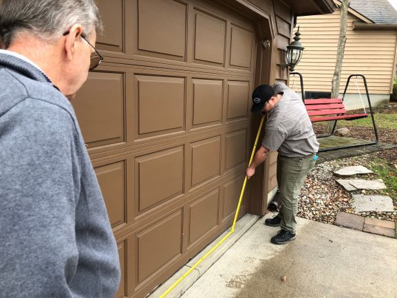 Precision Garage Door Toledo Technician Measuring Base of Garage Door