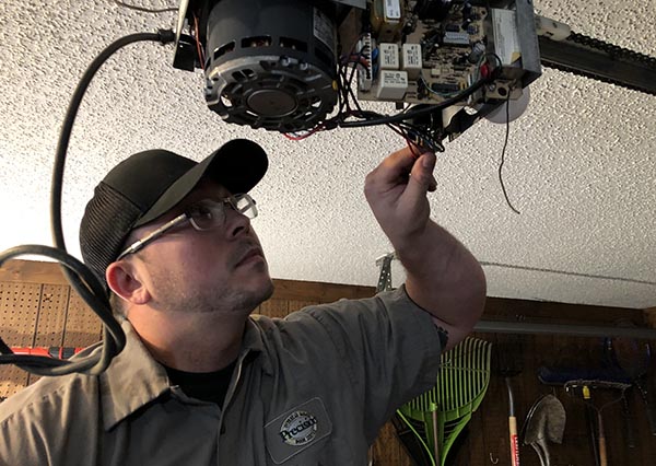 Technician Inspecting Garage Door Opener